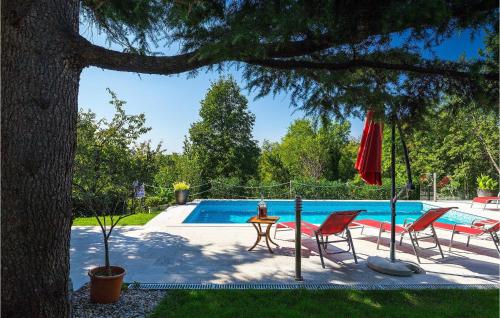 una piscina con dos sillas y una mesa y una sombrilla en Villa Perla, en Jadranovo