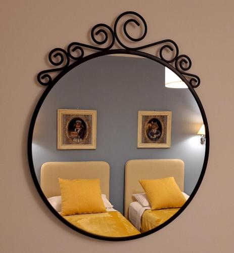 a mirror on a wall with two beds in a room at Casa Paola in Borso del Grappa