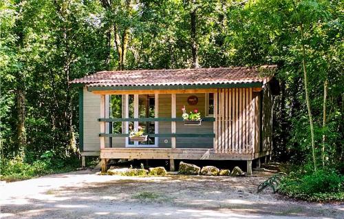 a small cabin with a porch in the woods at Gorgeous Stacaravan In Chef-Boutonne in Chef-Boutonne