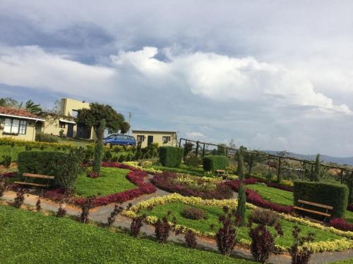 a garden with benches and flowers in a yard at Casa Emilia in Curití