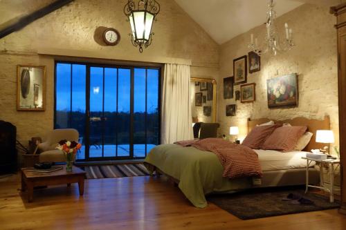 a bedroom with a large bed and a large window at La Passiflore B&B in Bossière