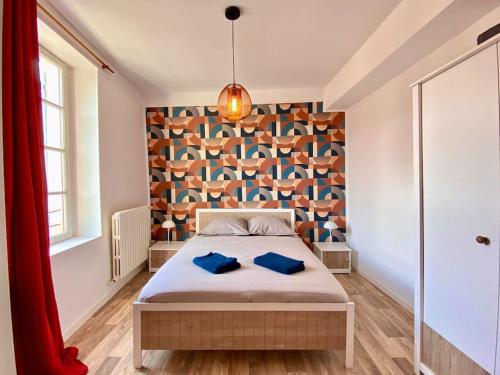 ein Schlafzimmer mit einem Bett mit blauen Kissen darauf in der Unterkunft Maison 2 chambres, village calme - Village Vaux 3 minutes Auxerre in Auxerre