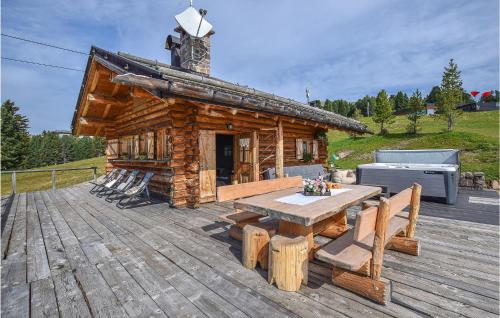 a log cabin with a table and chairs on a deck at Chalet Luisa in Predazzo