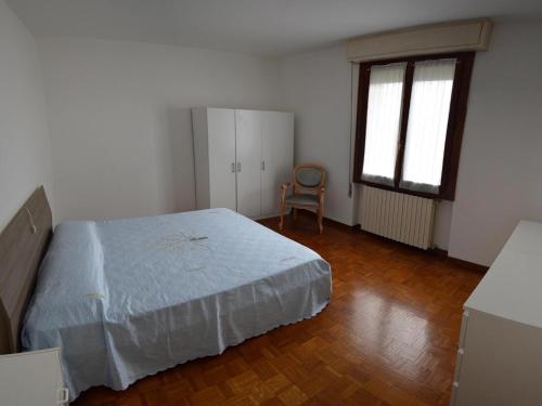 um quarto com uma cama e uma cadeira em Appartamento San Benedetto em Desenzano del Garda