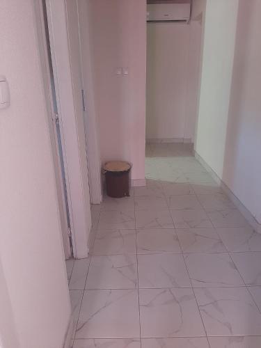 a hallway with a tile floor and a trash can at Vila Nina 