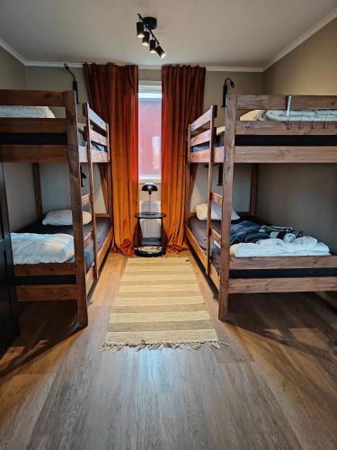 a room with three bunk beds and a rug at Stuga utanför Skövde 2 in Skövde