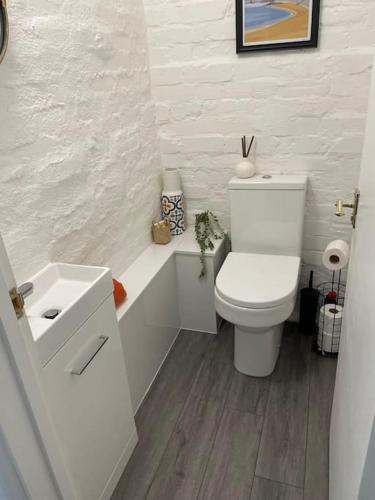 a white bathroom with a toilet and a sink at Classy 2 bed-sleeps 4-king& twin rooms-free parking-close to town & beach in Exmouth