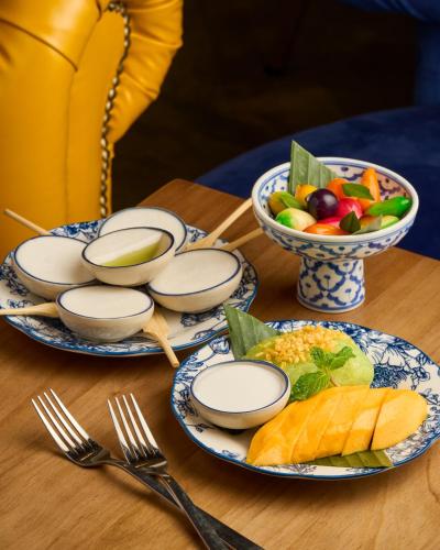 a table with plates of food and bowls of fruit at AMOY by Far East Hospitality in Singapore