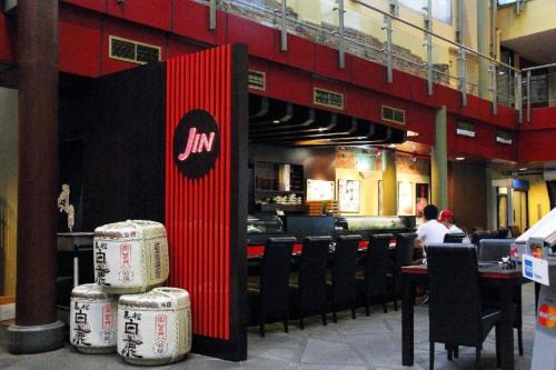 a restaurant with tables and chairs and a red wall at AMOY by Far East Hospitality in Singapore