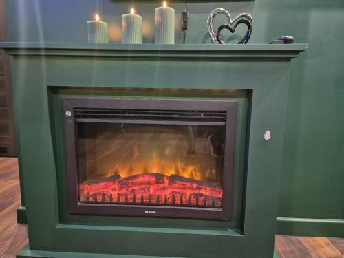 a fireplace with some candles in a room at Make Love Apartament by Secret Apartament in Toruń