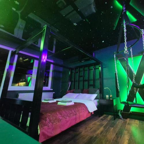a bedroom with a bed with green and purple lights at Make Love Apartament by Secret Apartament in Toruń