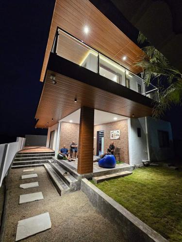 a house with people sitting outside of it at night at Krishna Villa in Shirwal