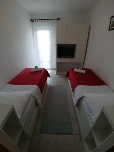 two beds sitting in a room with a tv at Apartment Svetka in Sali