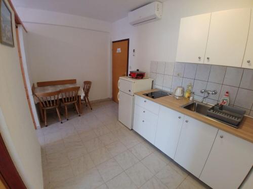 a kitchen with a sink and a table with a dining room at Apartment Svetka in Sali