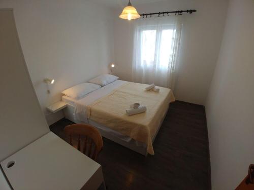 a small bedroom with a bed and a window at Apartment Svetka in Sali