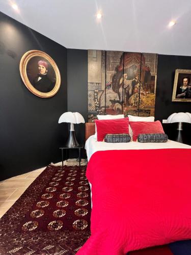 a bedroom with a large bed with a red blanket at Villa Pauline in Avignon