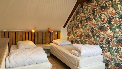 - 2 lits dans une chambre avec une fresque murale dans l'établissement Chez Louise, à Vitrac