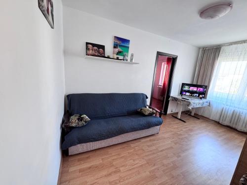 バカウにあるCozy Apartmentsの青いソファとテレビのあるリビングルーム