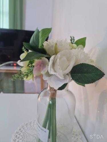 a glass vase with white flowers in it on a table at #A6 Open sale - 5mins to Hongdae Station in Seoul