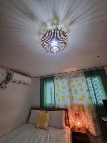 a bedroom with a bed and a ceiling with a chandelier at #A6 Open sale - 5mins to Hongdae Station in Seoul