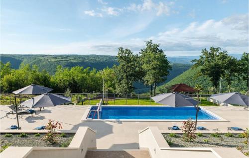 a pool with umbrellas and a view of the mountains at Villa Callista in Ružići