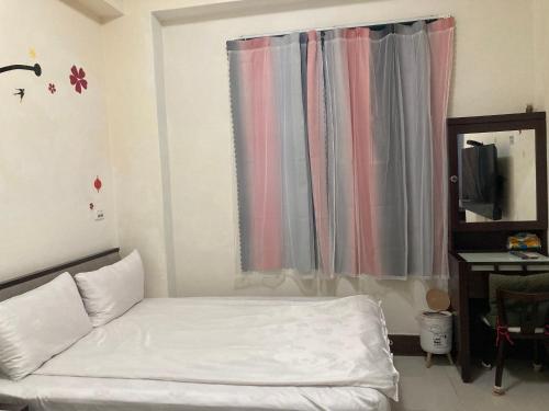a small bedroom with a bed and a window at 福田民宿 台東民宿476號 in Guanshan