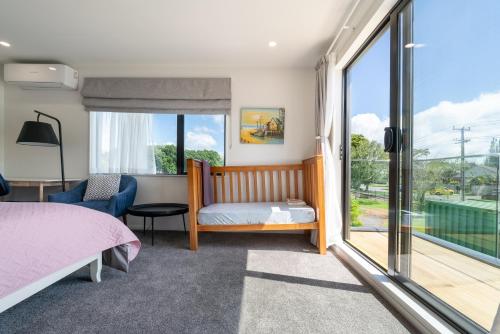 Un dormitorio con una cama y una puerta corrediza de vidrio. en Auckland ONE Tree Hill Coby Suite, en Auckland