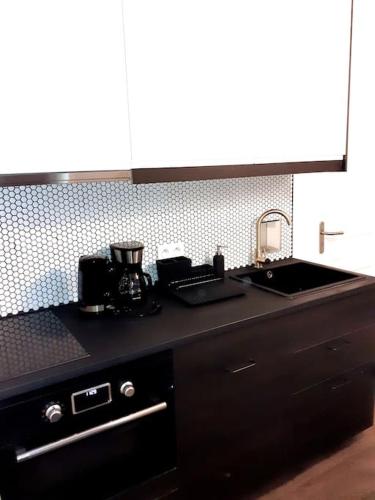 une cuisine avec un évier et un plan de travail dans l'établissement Studio de charme neuf Tourny Hyper centre Bordeaux, à Bordeaux