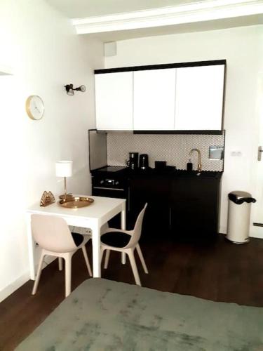 une chambre avec une table et deux chaises ainsi qu'une cuisine dans l'établissement Studio de charme neuf Tourny Hyper centre Bordeaux, à Bordeaux