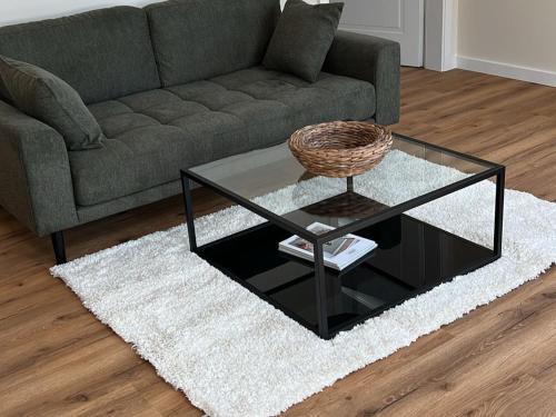 a living room with a couch and a glass coffee table at GUNDT Amrum in Nebel
