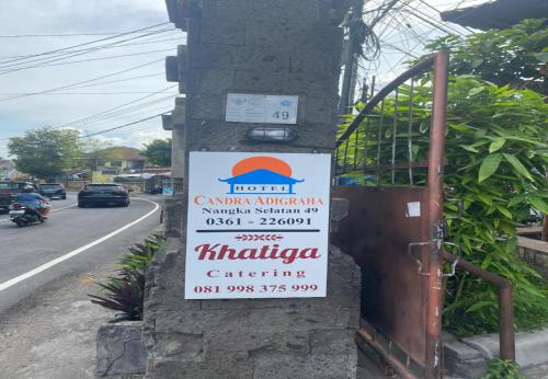 a sign for a restaurant on the side of a building at Hotel Candra Adigraha in Denpasar
