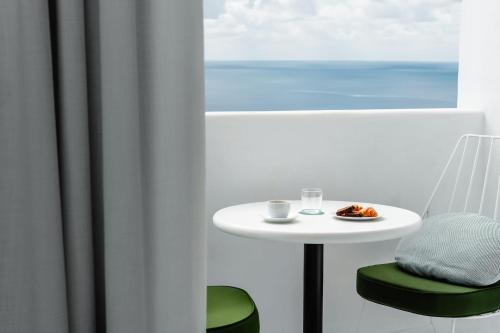 a white table and chair with a plate of food at Croco Mykonos in Tourlos