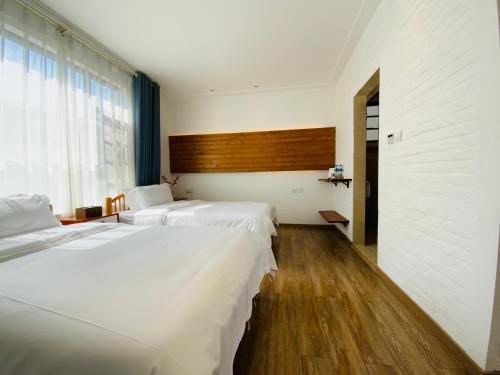 a bedroom with two beds and a large window at 叁三民宿 in Dali