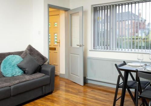 a living room with a couch and a table at Comfortable 3 Bedrooms Leeds Beach House - Ideal for Family and Contractors - Free WIFI, Projector in bedroom and Free Parking for 2 cars in Killingbeck