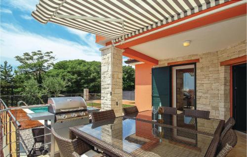 patio z grillem i krzesłami na balkonie w obiekcie 4 Bedroom Awesome Home In Umag w mieście Murine