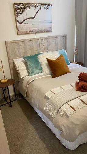 a bedroom with a bed with pillows on it at Rosebud Beach Cottage in Rosebud