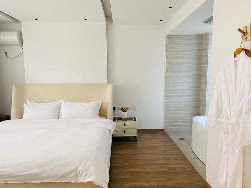 a bedroom with a large white bed and a tub at 叁三民宿 in Dali