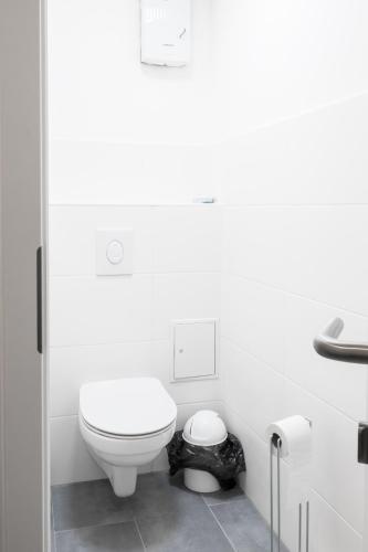 a white bathroom with a toilet and a sink at Hostel MaRu Living C9 in Cologne