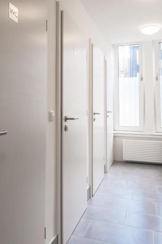 an empty hallway with white walls and a window at Hostel MaRu Living C9 in Cologne