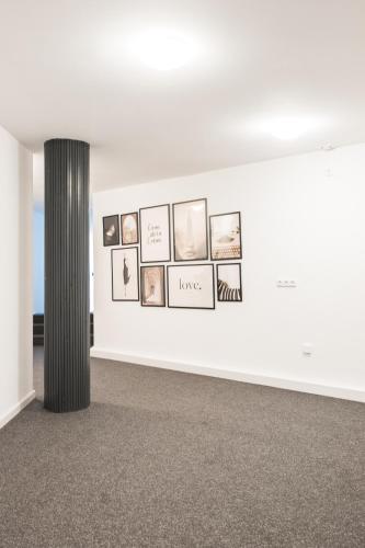 a white room with photographs on a wall at Hostel MaRu Living C9 in Cologne