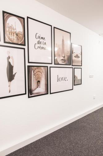 a gallery wall with pictures on a white wall at Hostel MaRu Living C9 in Cologne