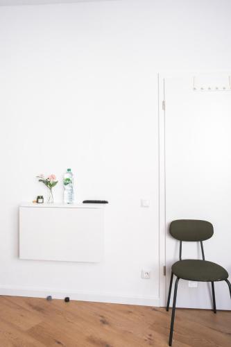 a chair in a room with a white wall at Hostel MaRu Living C9 in Cologne