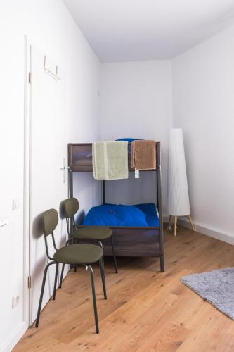 a bedroom with a bunk bed and a chair at Hostel MaRu Living C9 in Cologne