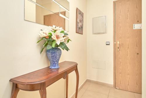 a vase with flowers on a table in a hallway at Apartamento Lola 1 in Nerja