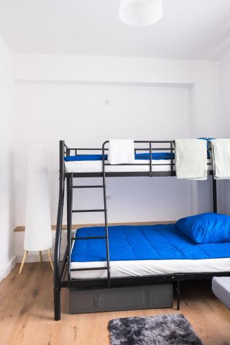 a bunk bed with blue sheets and a ladder at Hostel MaRu Living C9 in Cologne