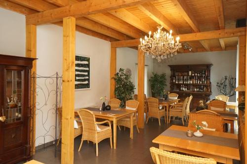 a dining room with tables and chairs and a chandelier at Harfenmühle Camping in Mörschied