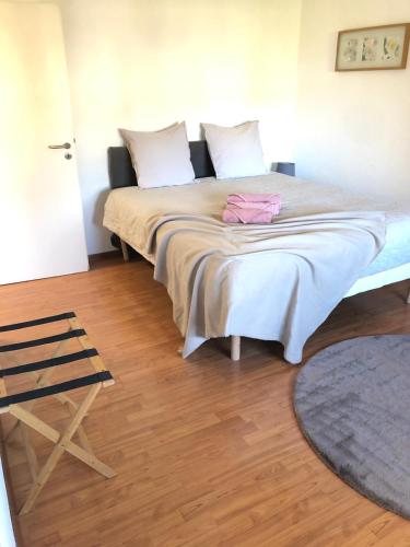 Cette chambre comprend un grand lit et du parquet. dans l'établissement Studio 7'4 - proche frontière de Bâle, à Saint-Louis