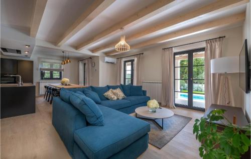 a living room with a blue couch and a kitchen at 5 Bedroom Nice Home In Manjadvorci in Manjadvorci