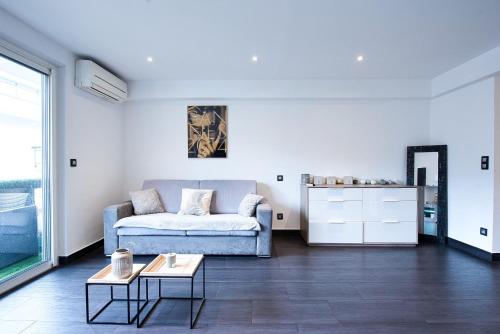 salon z kanapą i stołem w obiekcie LE VENITIA studio raffiné avec balcon mignon, pour votre séjour à deux w Cannes