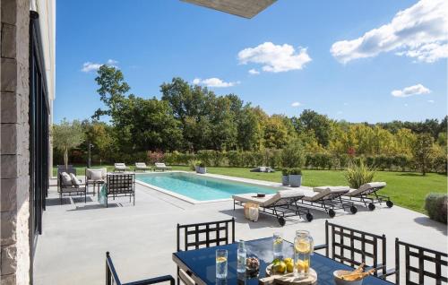 Un patio con piscina, mesas y sillas. en Villa Valens Residence, en Poreč